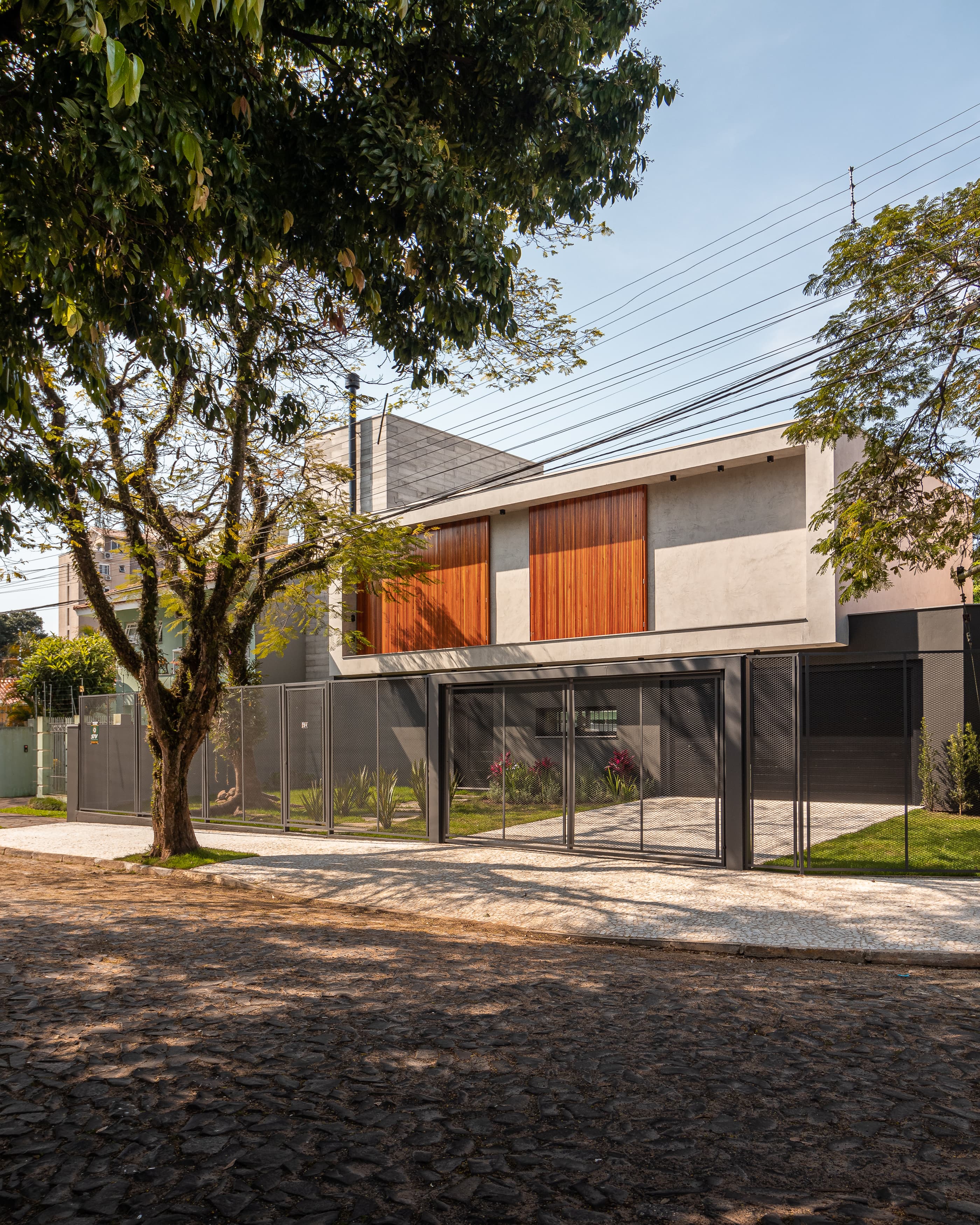 Localizada em São Leopoldo, cidade a cerca de 35km de Porto Alegre, a Casa AMI foi projetada com um partido que permite um layout flexível, ao mesmo tempo em que dialoga com a vizinhança e aproveita o terreno profundo e angulado para criar um espaço intimista ao meio a uma cidade consolidada.